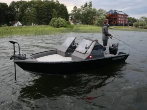 Person som fiskar från en svart fiskebåt